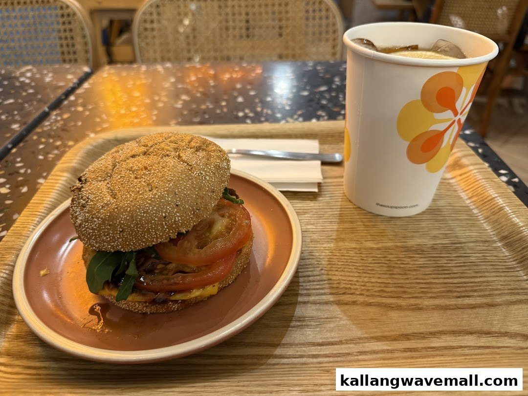 A hearty burger and refreshing iced tea served on a wooden tray at The Soup Spoon Union.