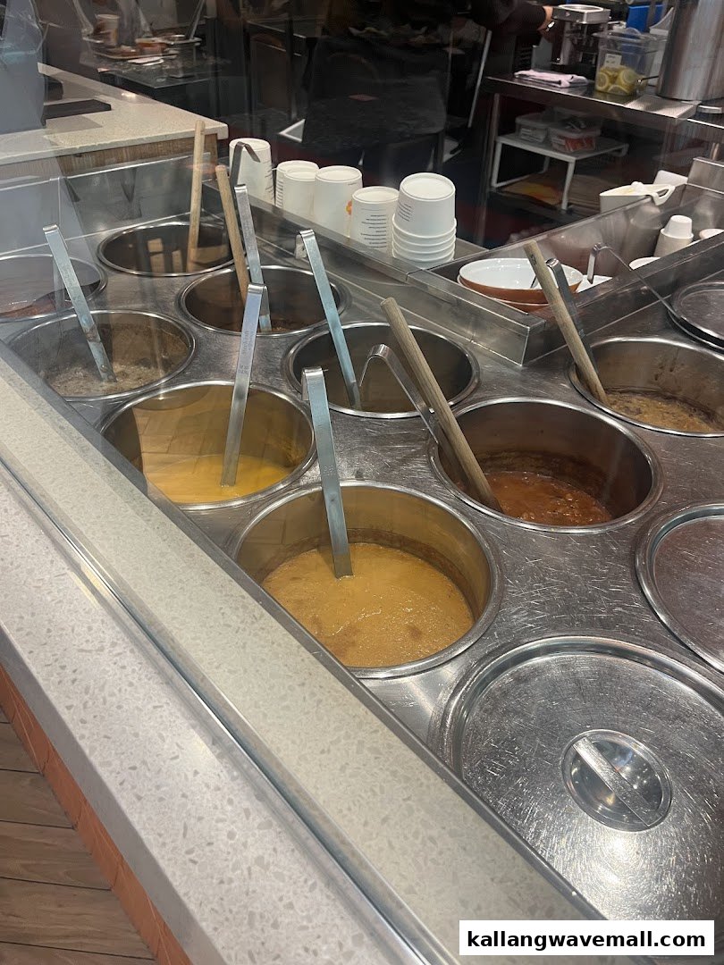 A vibrant soup bar showcasing various hot soup selections with ladles at The Soup Spoon Union.