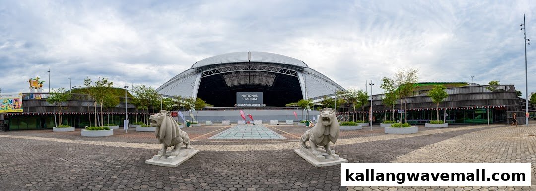A panoramic view of the National Stadium and surrounding buildings at Singapore Sports Hub, featuring lion statues.