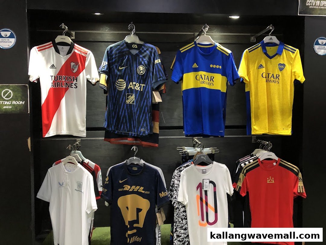 A display of various football club jerseys, including Adidas and Nike brands, hanging in a retail store.
