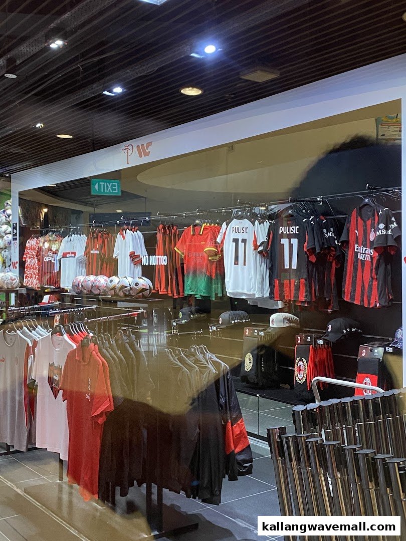 An interior view of a sports apparel store showcasing football jerseys, including AC Milan merchandise.