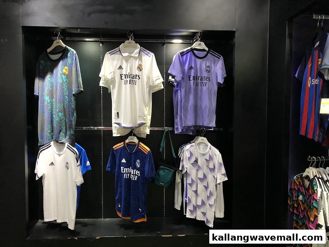 An interior view of Weston Corp showcasing a display of various Adidas football jerseys, including Real Madrid kits.