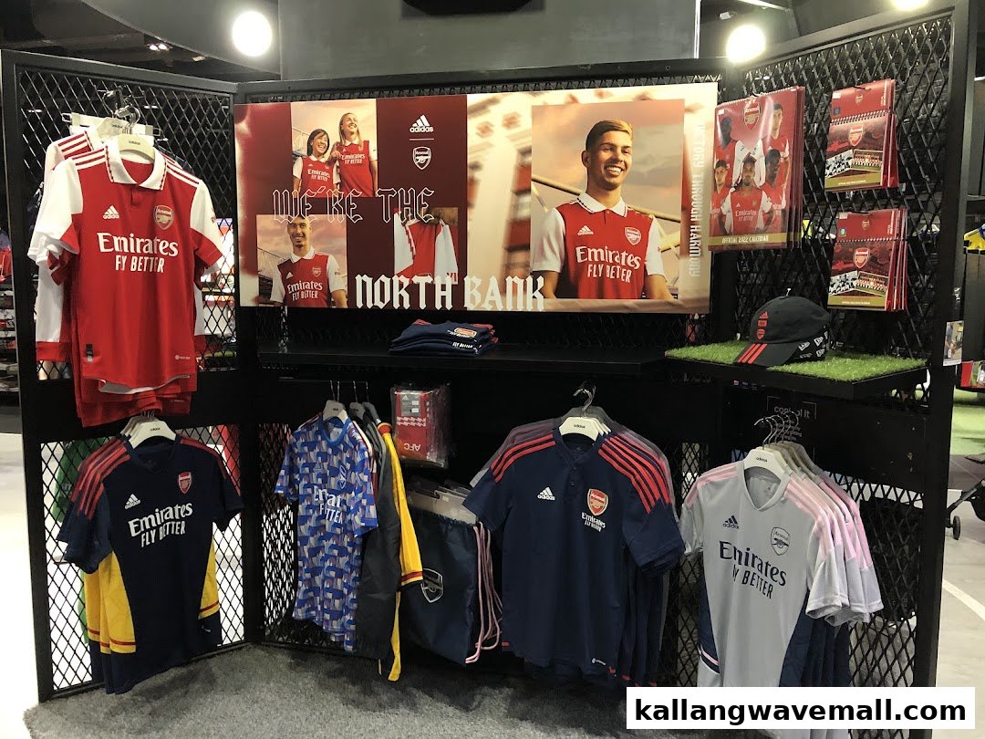 An in-store display featuring official Arsenal FC football jerseys, apparel, and merchandise.
