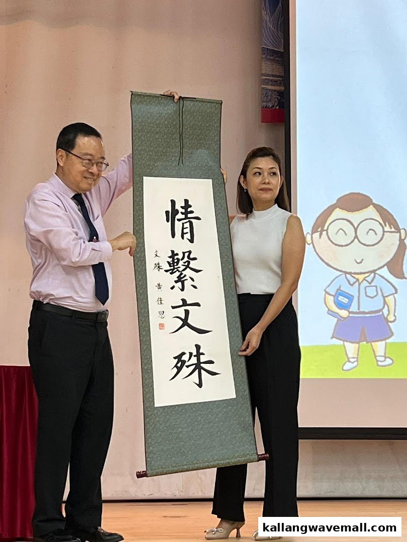 Two individuals present a large scroll featuring elegant Chinese calligraphy on stage.