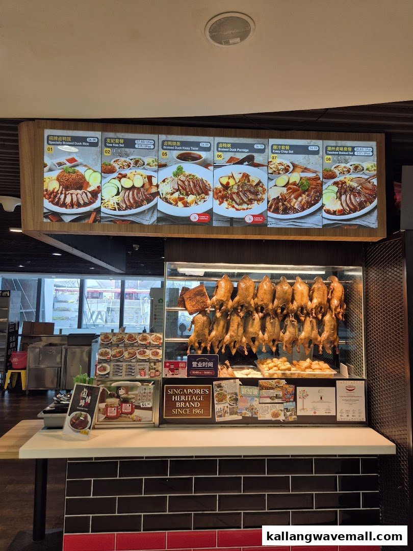 A food stall's menu board displaying various braised duck dishes and sets, with roasted ducks on display.