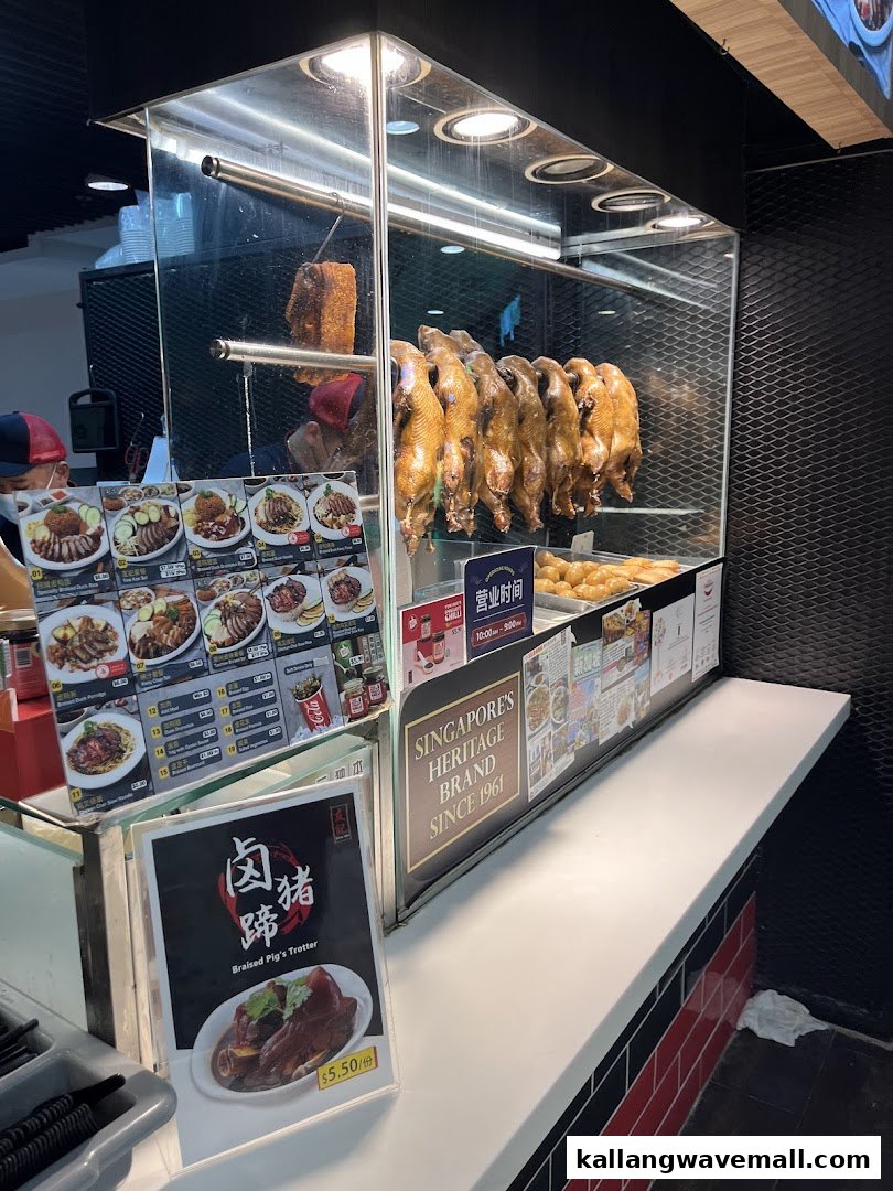 A food stall counter showcasing roasted ducks, pork, and various menu items.