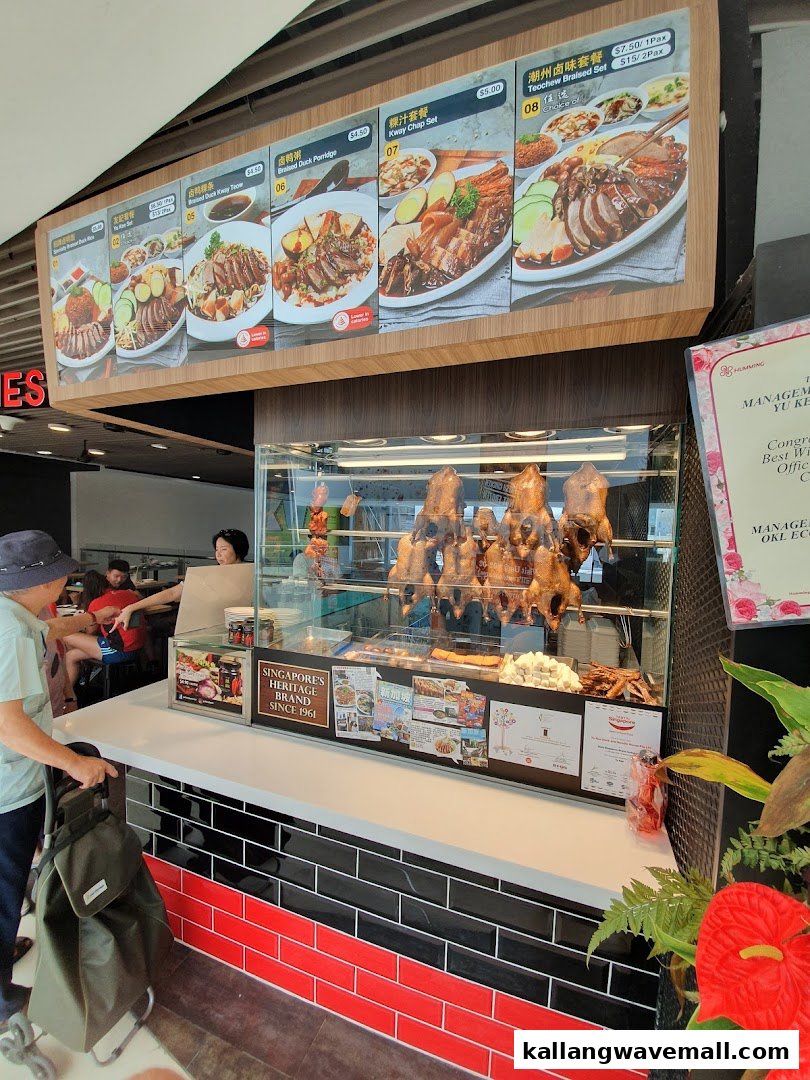 A vibrant display of roasted ducks and a menu board showcasing traditional braised dishes at Yew Kee Specialities.