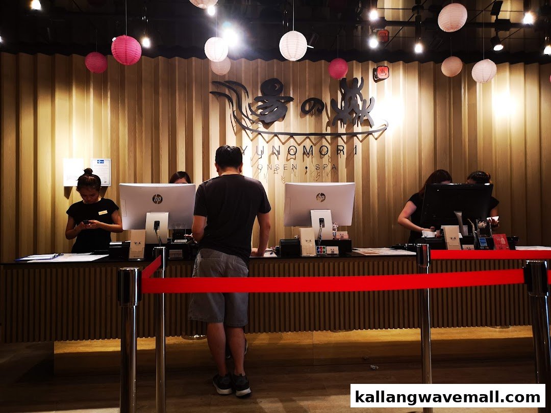 Customers check in at the welcoming reception desk of Yunomori Onsen & Spa, adorned with traditional lanterns.