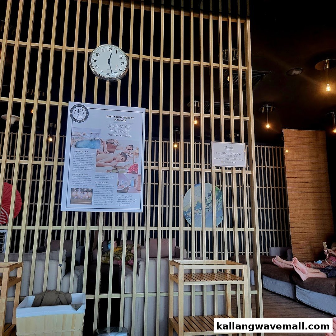 Interior view of a spa lounge with wooden partitions, comfortable seating, and a promotional poster.