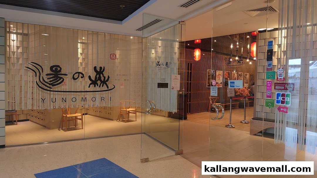 The inviting glass entrance of Yunomori Onsen & Spa, featuring Japanese-inspired decor and branding.