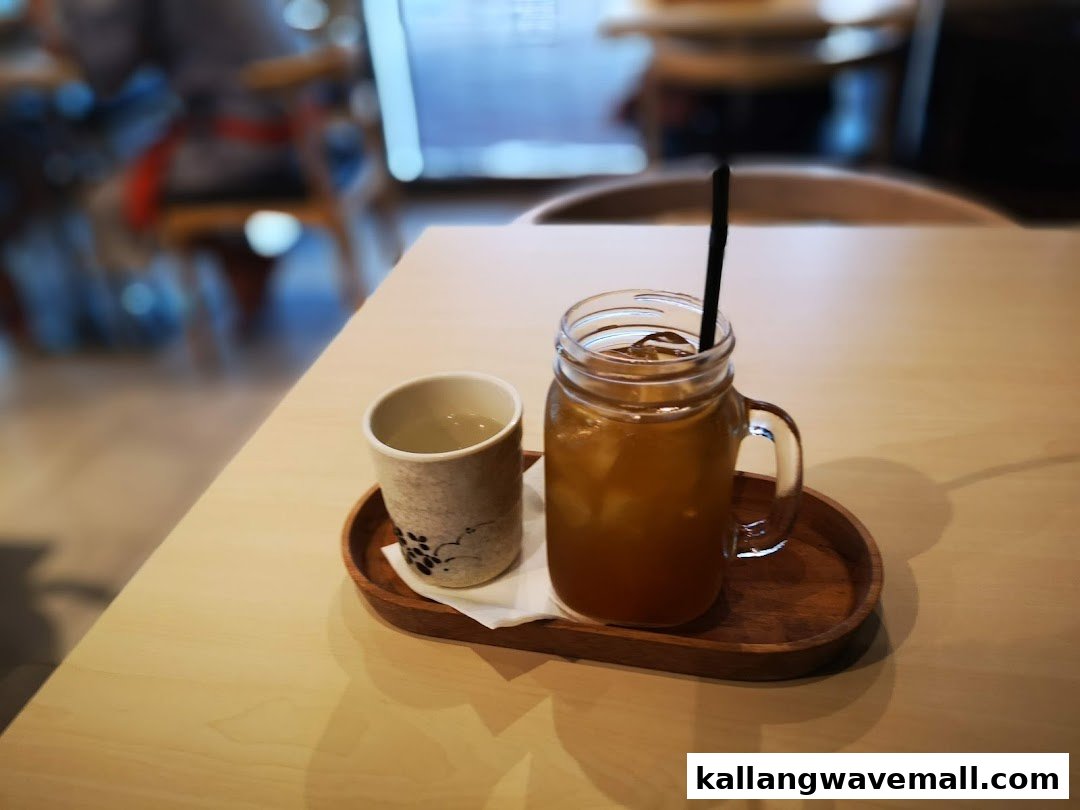 Two refreshing drinks, one iced and one hot, served on a wooden tray at a table.