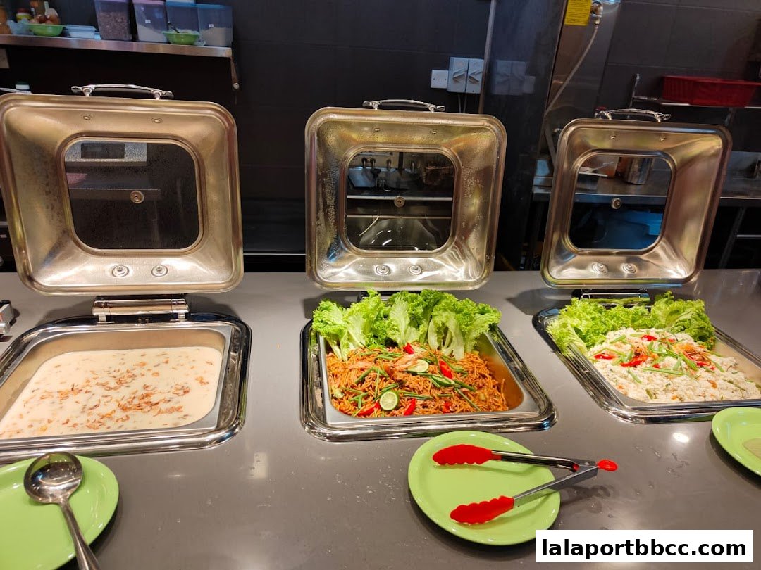 Buffet style food display with three chafing dishes containing various dishes.