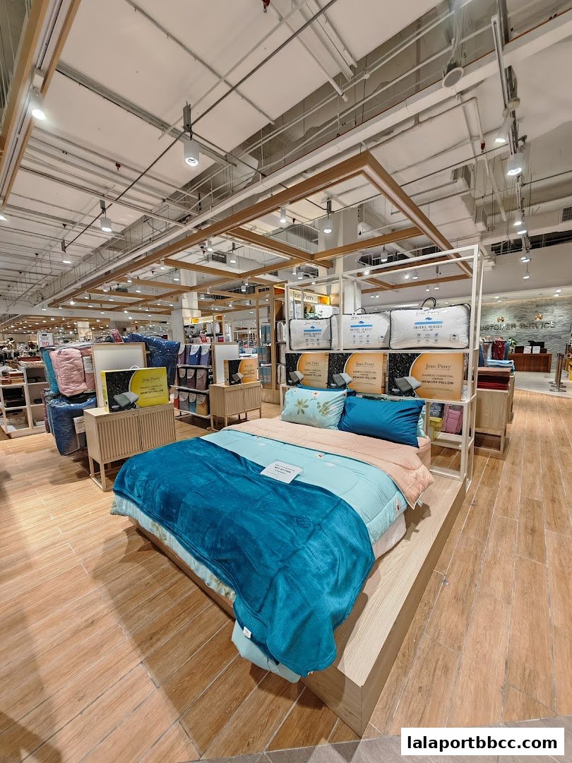 A beautifully made bed display with plush bedding and pillows in a retail store.