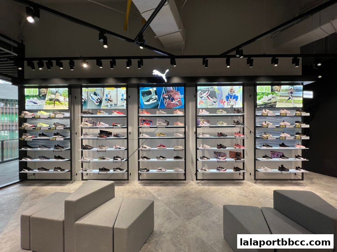 Interior view of a PUMA store showcasing a wide selection of athletic footwear on display shelves.