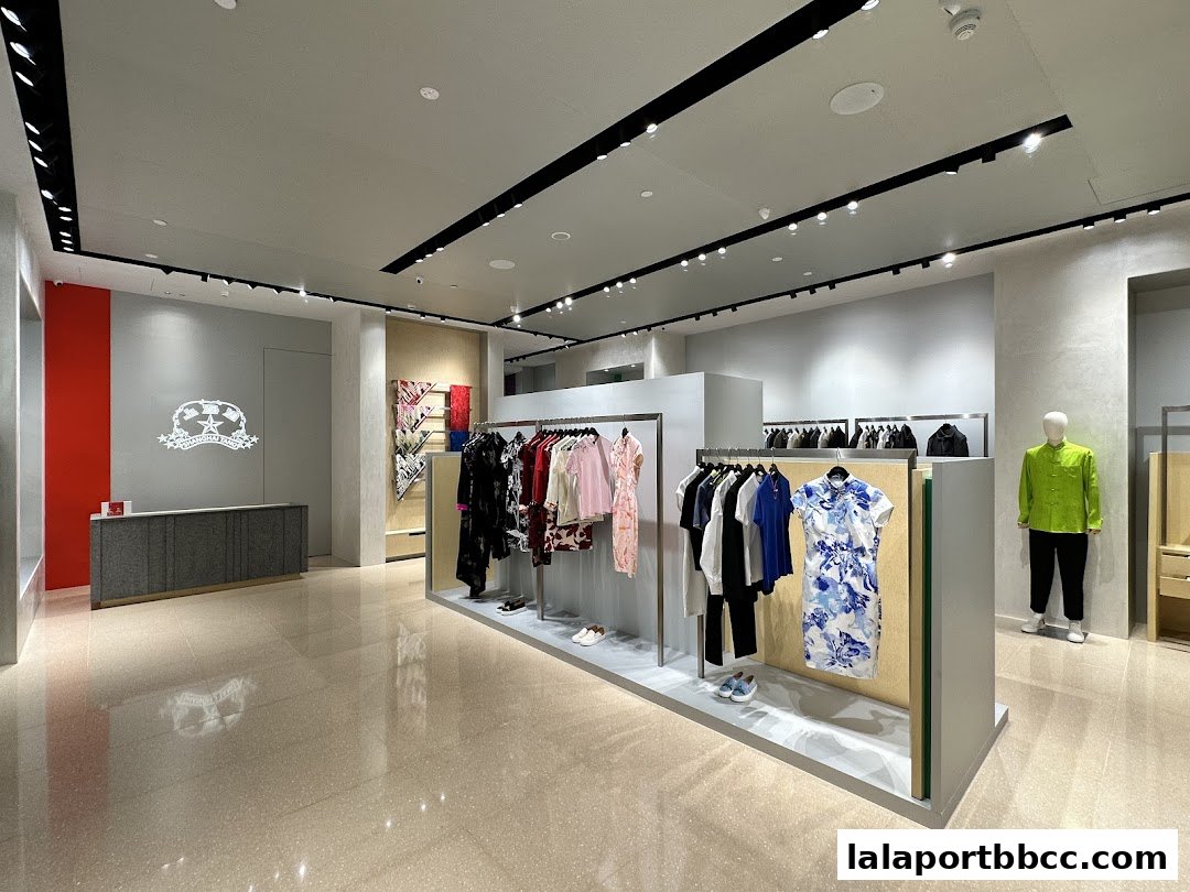 Interior view of a Shanghai Tang store showcasing clothing on racks and a mannequin.
