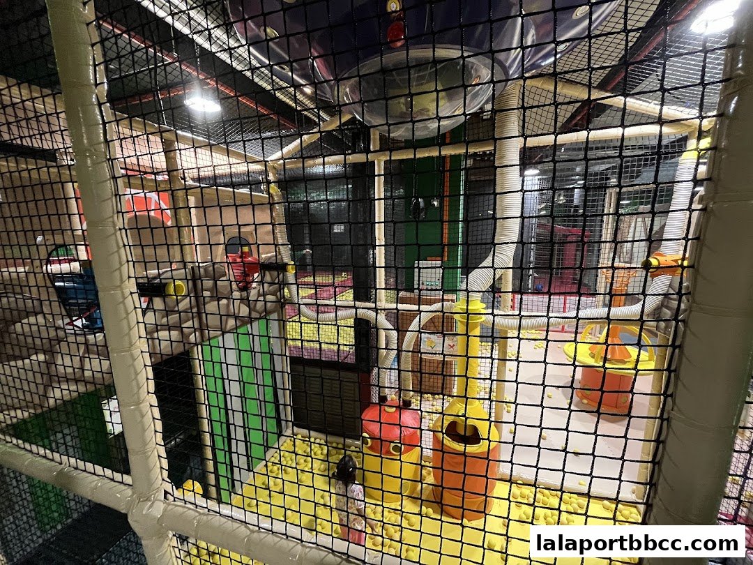 Interior view of a colorful indoor playground with soft play structures and a ball pit.