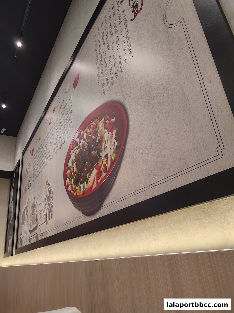 A large framed poster on a wall featuring a bowl of noodles and Chinese text.