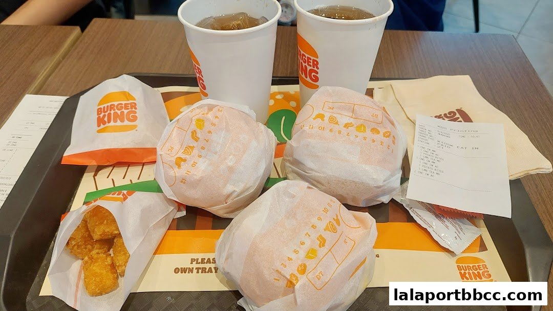 A tray of Burger King meals including burgers, potato bites, and drinks.