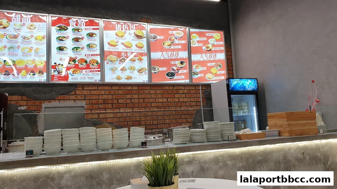 A brightly lit menu board displays various Chinese desserts and snacks with appealing food photography.