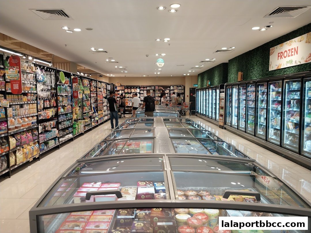Interior view of a well-stocked supermarket with aisles of products and refrigerated display cases.