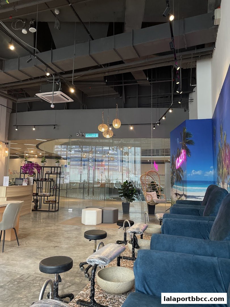 Interior of a modern nail salon with pedicure chairs and a reception area.