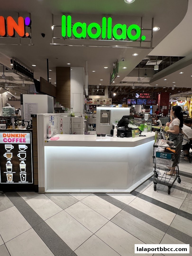 The llaollao shop counter with a Dunkin' Coffee sign and a shopping cart.
