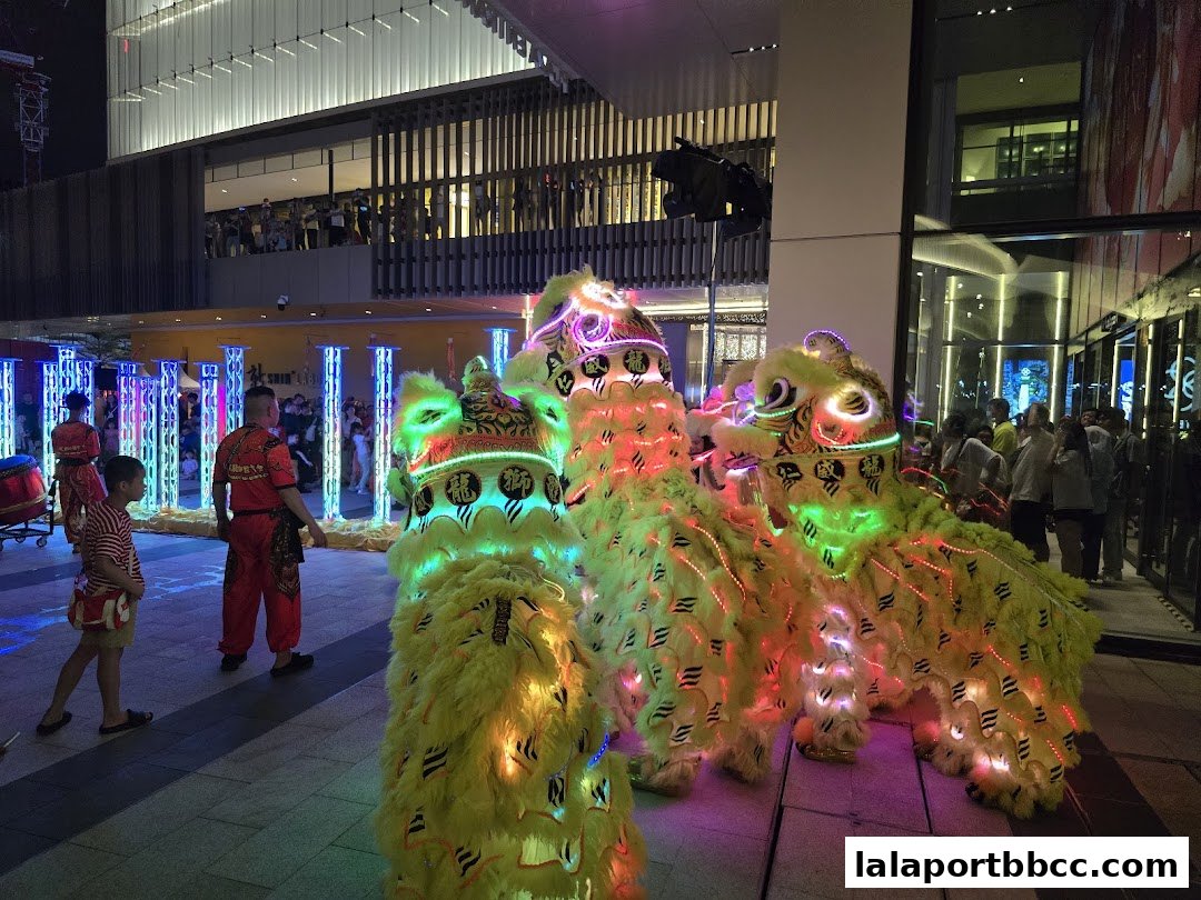 Lion dance performance with colorful costumes and lights at night.