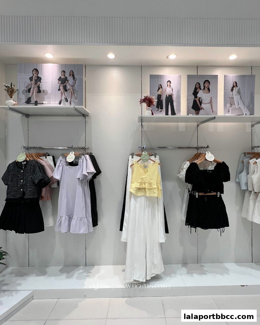A well-lit retail display showcasing various women's fashion outfits on hangers and mannequins.