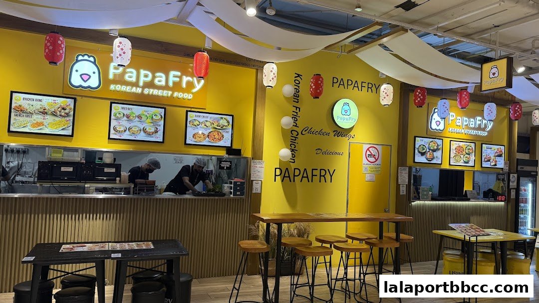 PapaFry Korean Street Food shop with bright yellow walls, menu displays, and seating.