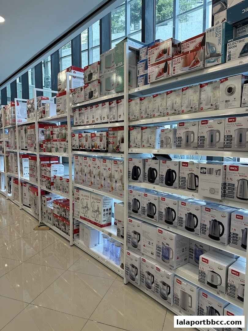 Shelves stocked with various home appliances like electric irons and kettles.