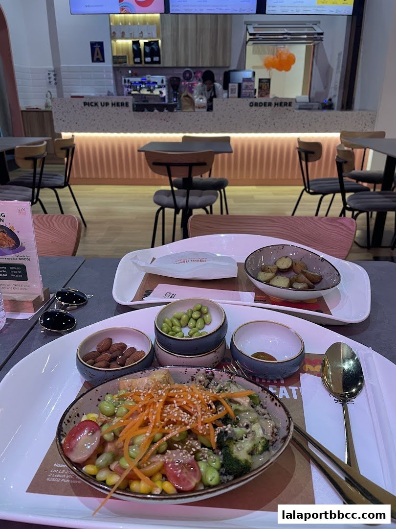 A healthy grain bowl with edamame, corn, tomatoes, carrots, and broccoli, served with sides of almonds and potatoes.