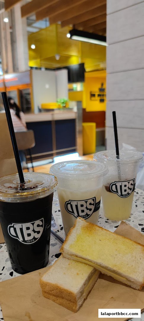 A close-up of buttered toast and three drinks from TBS Food Heritage.