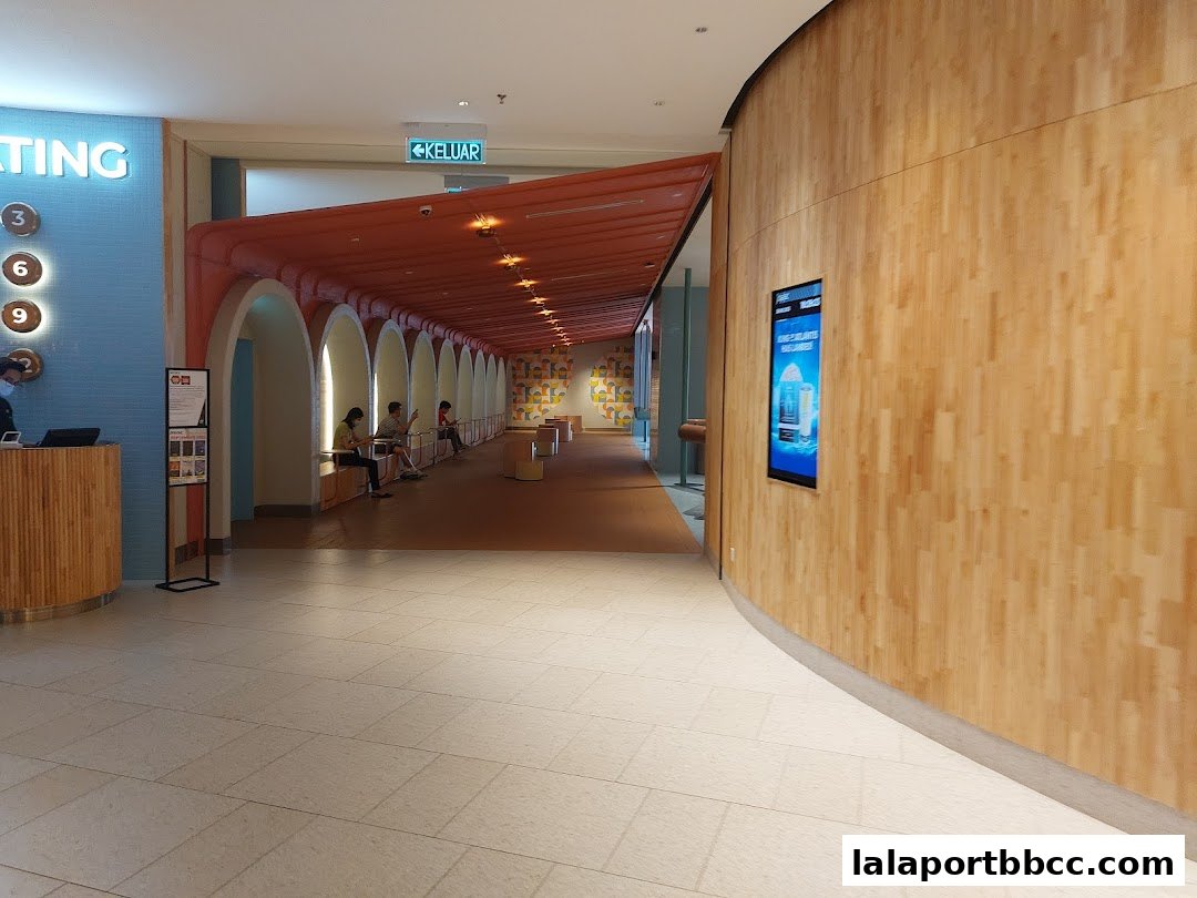 A modern interior hallway with arched walkways and a digital display on a wooden wall.
