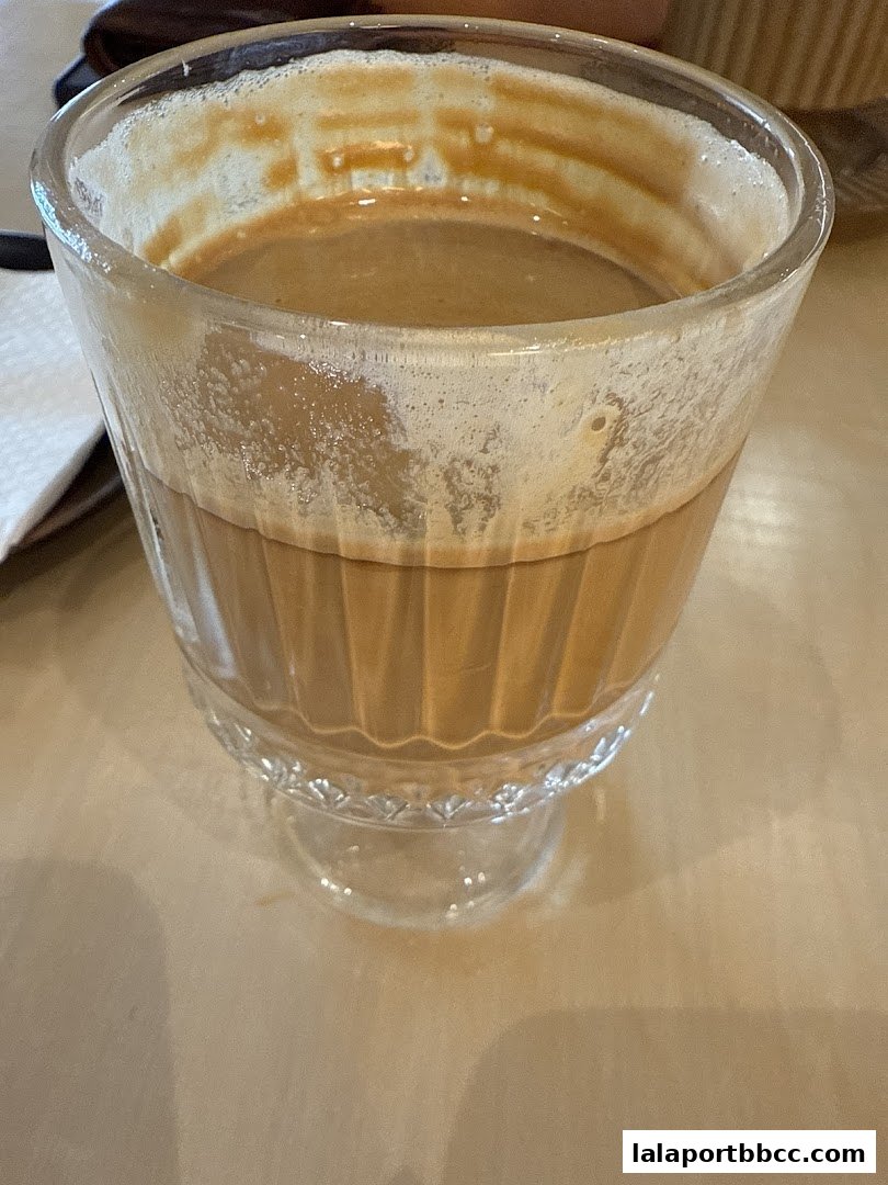 A close-up shot of a frothy, creamy beverage in a fluted glass.