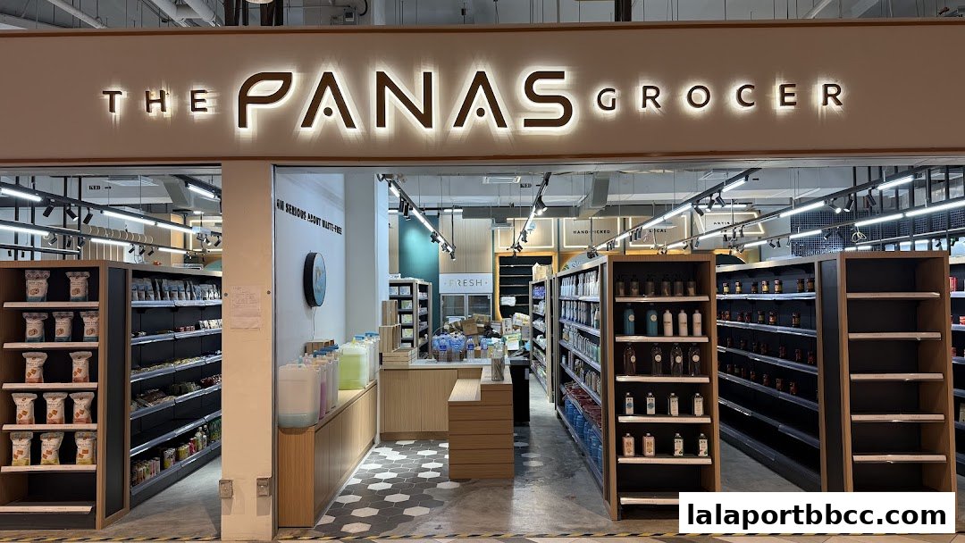 The entrance of The Panas Grocer, showcasing shelves stocked with various products and a clean, modern interior.
