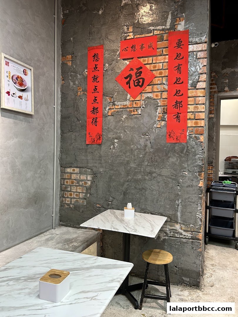 Interior of a dessert shop with tables, chairs, and decorative Chinese calligraphy on the wall.
