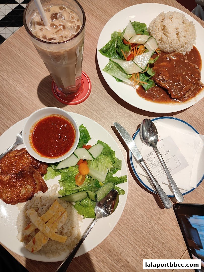 Two plates of food and a drink are arranged on a wooden table.
