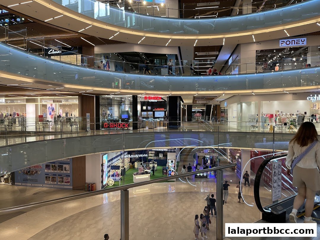 Interior view of a modern shopping mall with multiple levels and various retail stores.