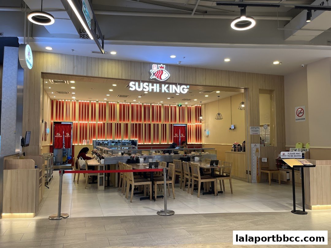 The entrance of Sushi King Lalaport BBCC, featuring a conveyor belt sushi bar and dining area.