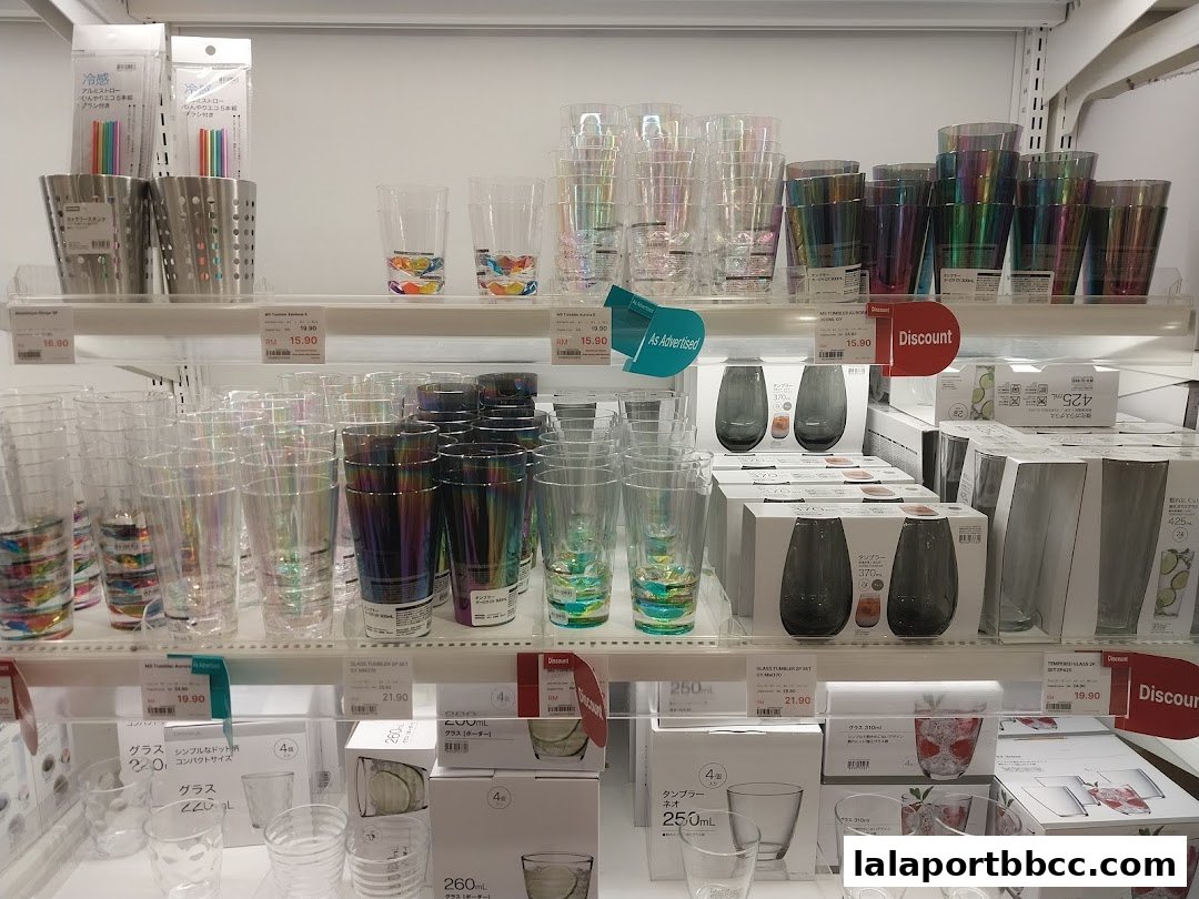 Shelves filled with various glassware, including tumblers and drinking glasses with iridescent and patterned designs.