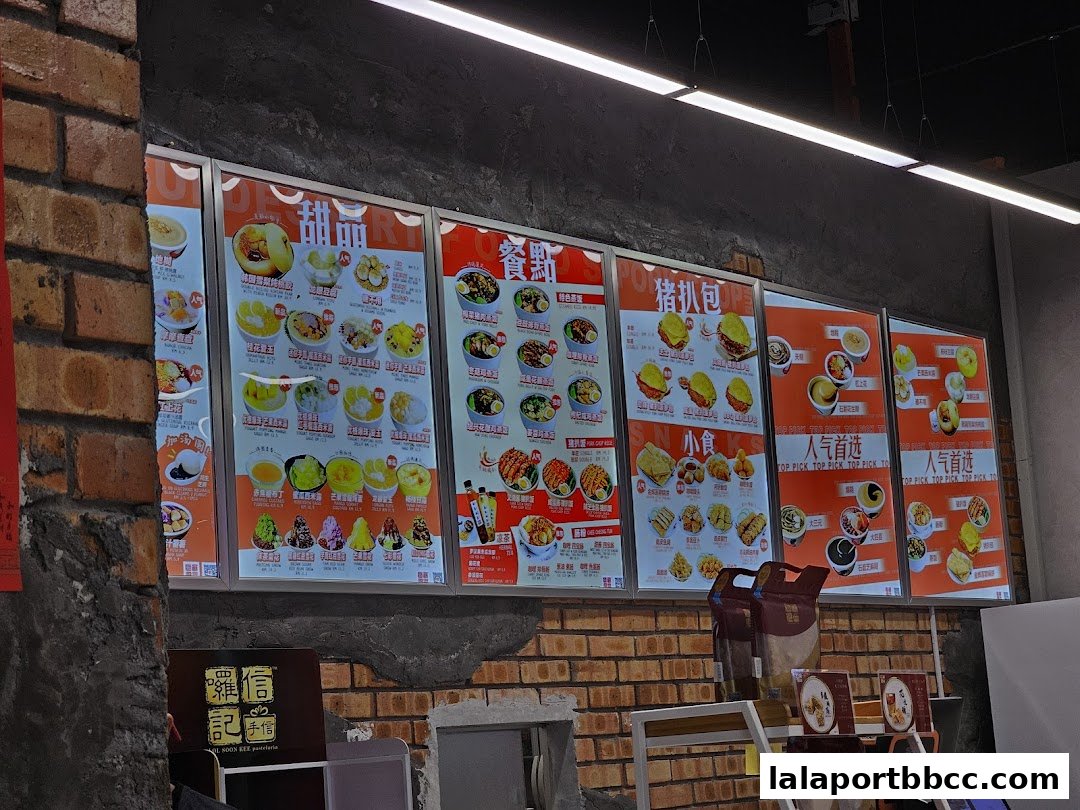 A brightly lit menu board displaying various desserts, snacks, and main dishes.