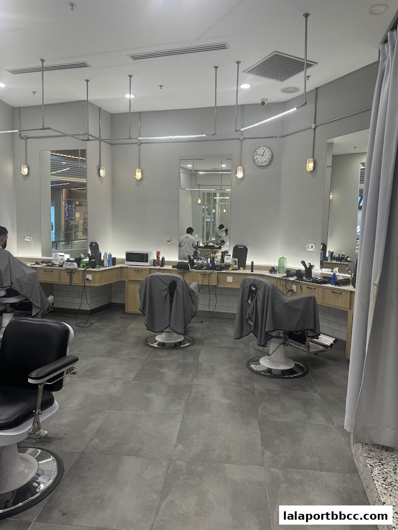Interior of a modern barbershop with barber chairs, mirrors, and styling stations.