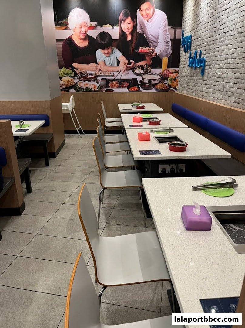 Interior view of a restaurant with tables set for dining, featuring a family mural.