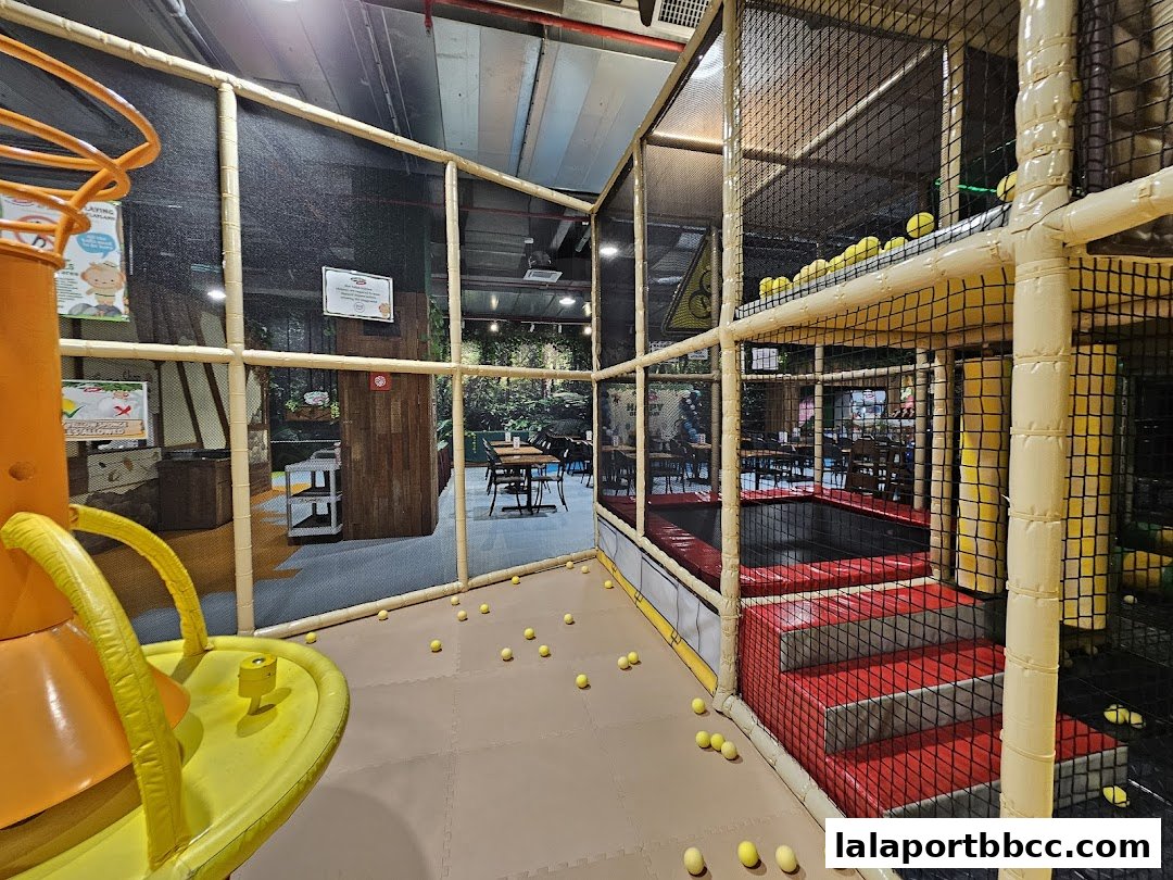 Interior view of a colorful indoor playground with soft play structures and seating areas.