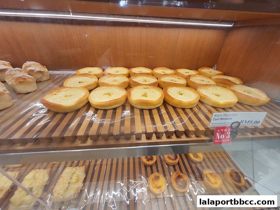 A display of freshly baked pastries, including tarts and bread, in a bakery.