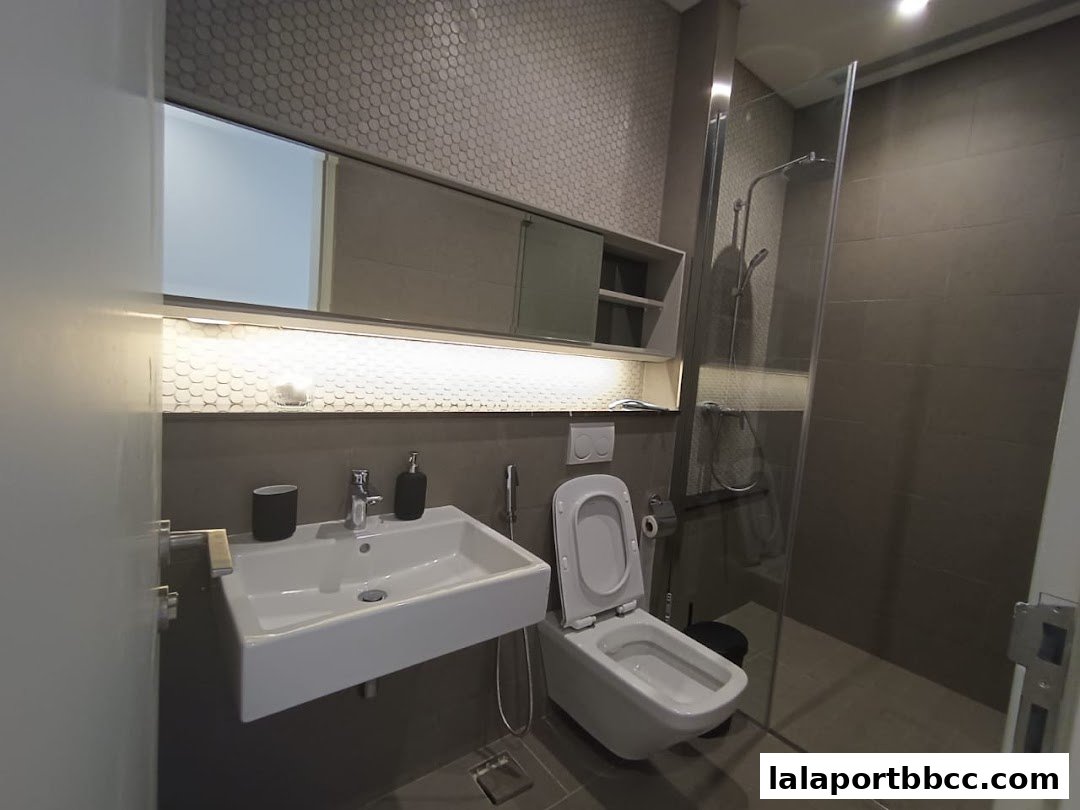 A modern bathroom with a sink, toilet, and glass-enclosed shower.