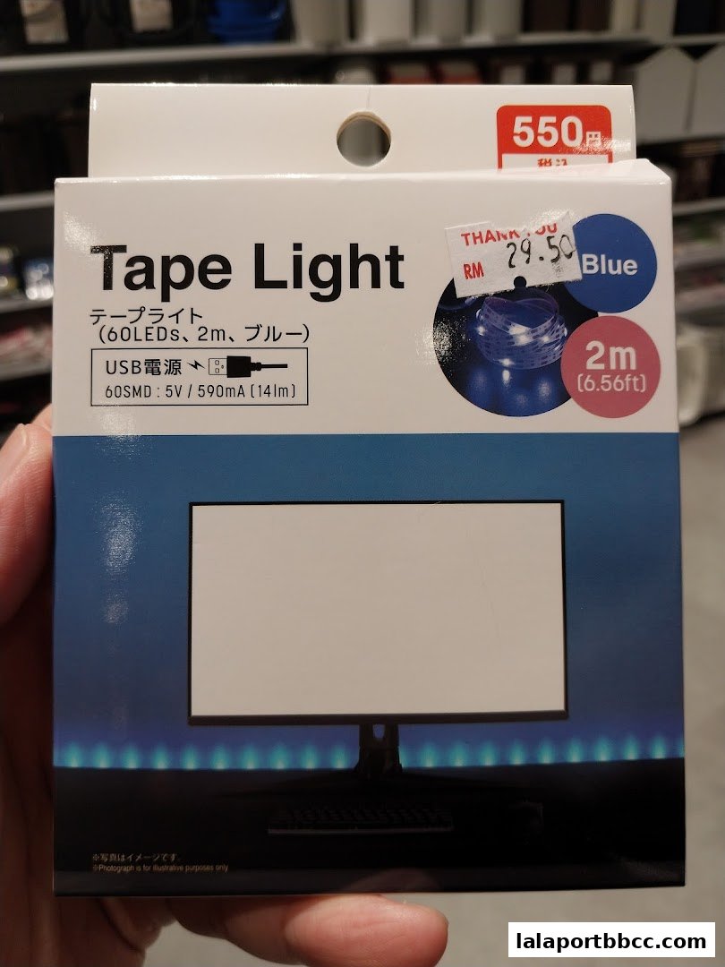 A hand holds a box for a blue 2m USB tape light with product details and price.