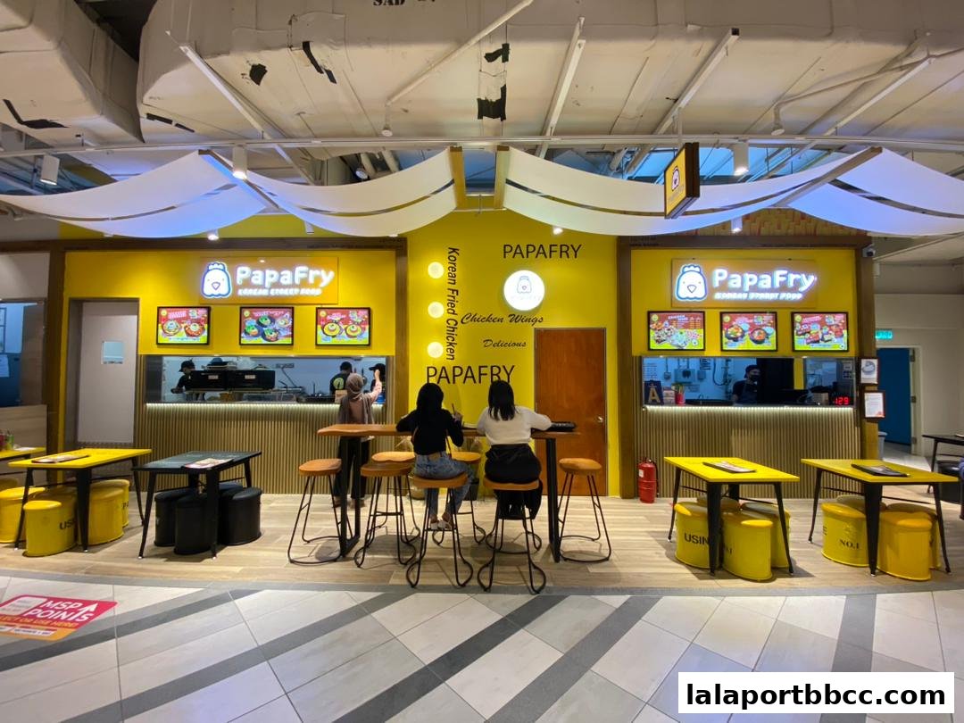 PapaFry Korean street food shop with bright yellow branding and seating areas.