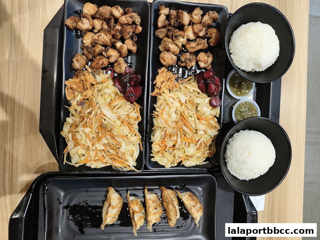 Two teppanyaki meals with grilled chicken, cabbage salad, rice, and dumplings.
