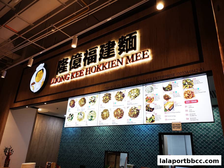 A brightly lit menu board for Loong Kee Hokkien Mee, showcasing various noodle dishes and drinks.